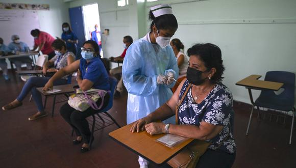 Una mujer recibe una segunda dosis de la vacuna Pfizer-BioNTech contra el COVID-19 en medio de la pandemia del nuevo coronavirus, en la escuela Belisario Porras del barrio San Francisco de la ciudad de Panamá. (Foto: LUIS ACOSTA / AFP)